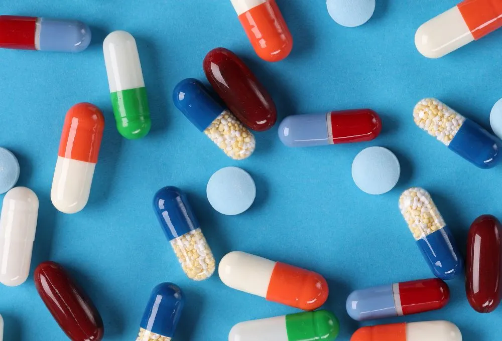 Assorted pills sitting on light blue background